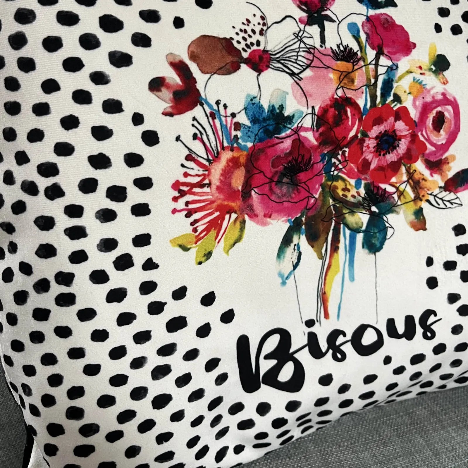 Détail du coussin à pois noirs avec bouquet de fleurs aquarelle colorées