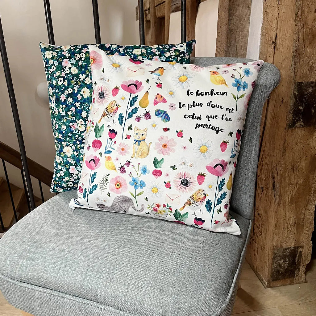 Détail coussin imagier avec chat, oiseaux, fleurs et inscription poétique