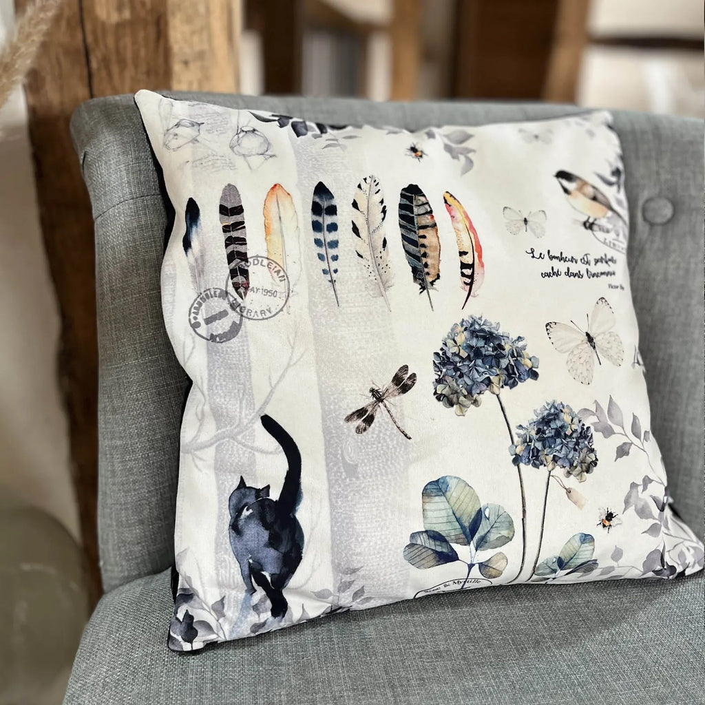 Coussin décoratif motif plumes, chat noir et hortensias bleus