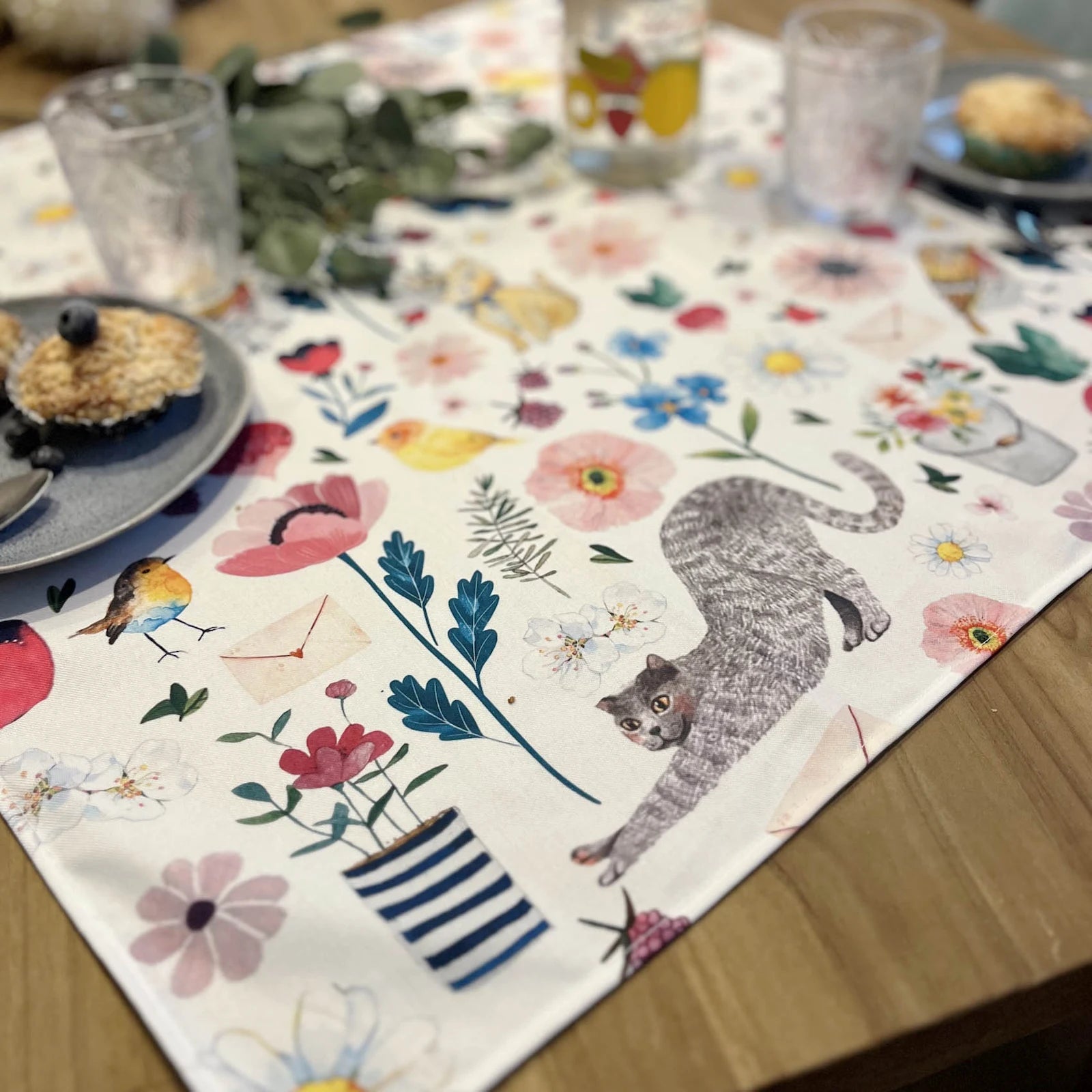 Petite nappe carrée illustrée Rose & Myrtille aux motifs floraux et animaux, idéale pour décoration de table.