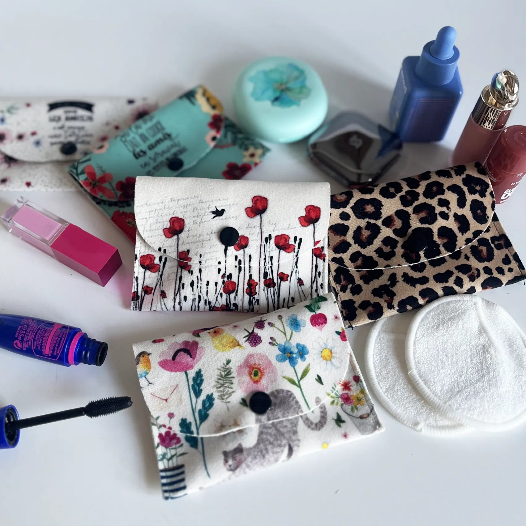 Pochettes à lingettes démaquillantes aux motifs coquelicots, fleurs et léopard, présentées avec des accessoires de maquillage