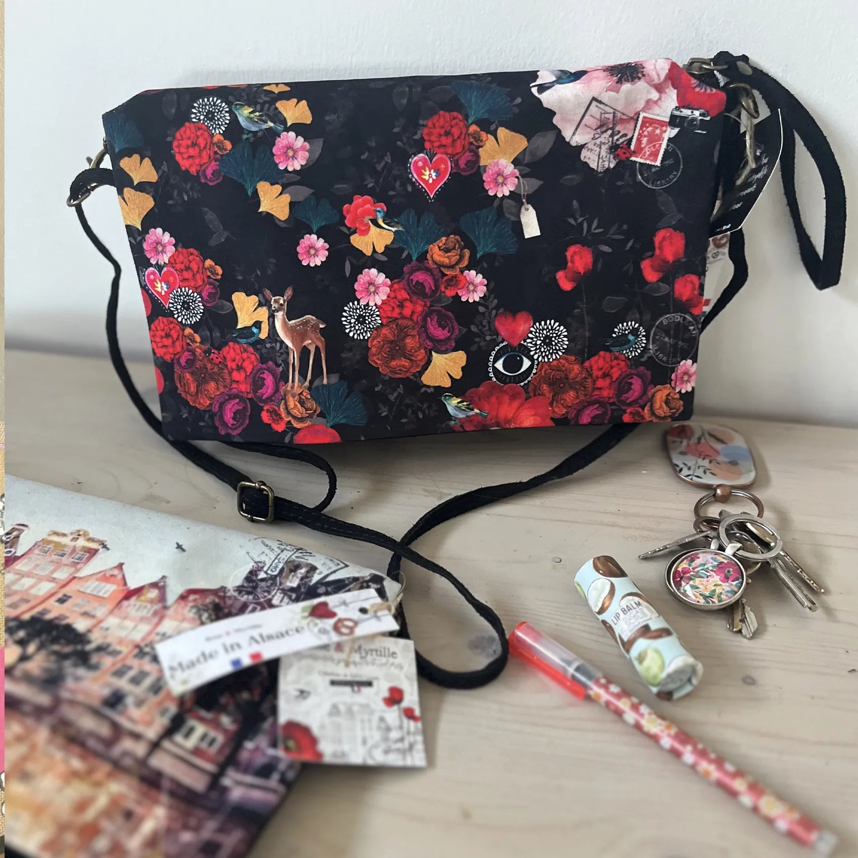 Sac à main bandoulière Rose & Myrtille à fond noir, illustré de fleurs colorées, d'oiseaux et d'un faon